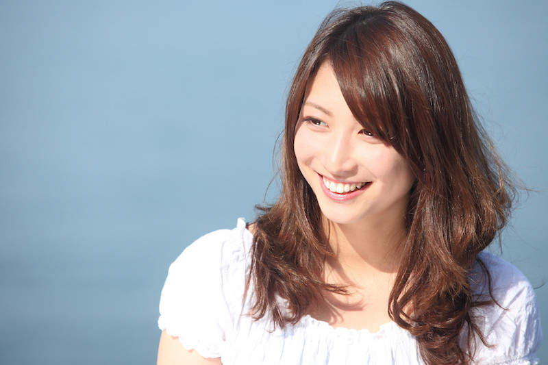 遠くを見て微笑んでいる女性